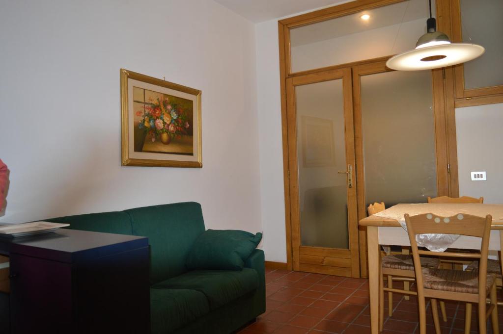 a living room with a green couch and a table at Borgo nel Centro in Ronciglione