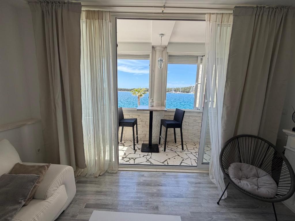 a living room with a view of the ocean at Apartman Cezar2 in Rogoznica