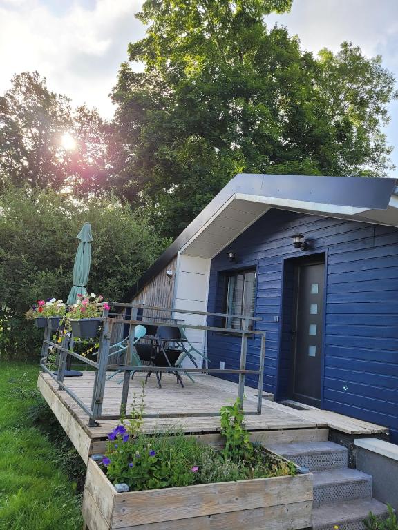 a blue tiny house with a porch and a deck at Le petit chalet in Mazaye