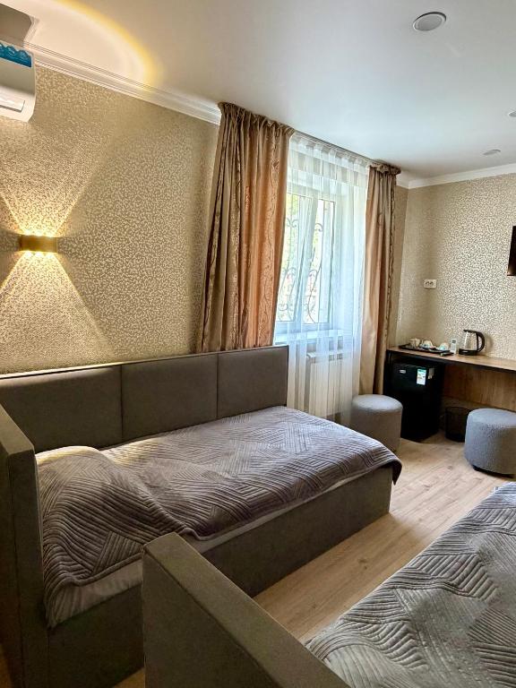a bedroom with a bed and a desk in a room at Sky 28 in Almaty