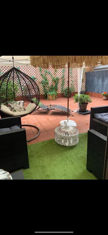 a patio with chairs and an umbrella and grass at Mar de Alcabre in Vigo