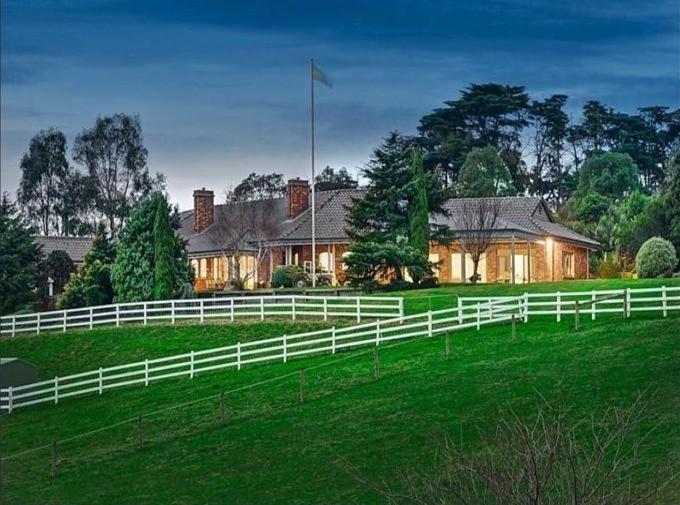 a white fence in front of a house at Oak Hill House - Chirnside Park in Wonga Park