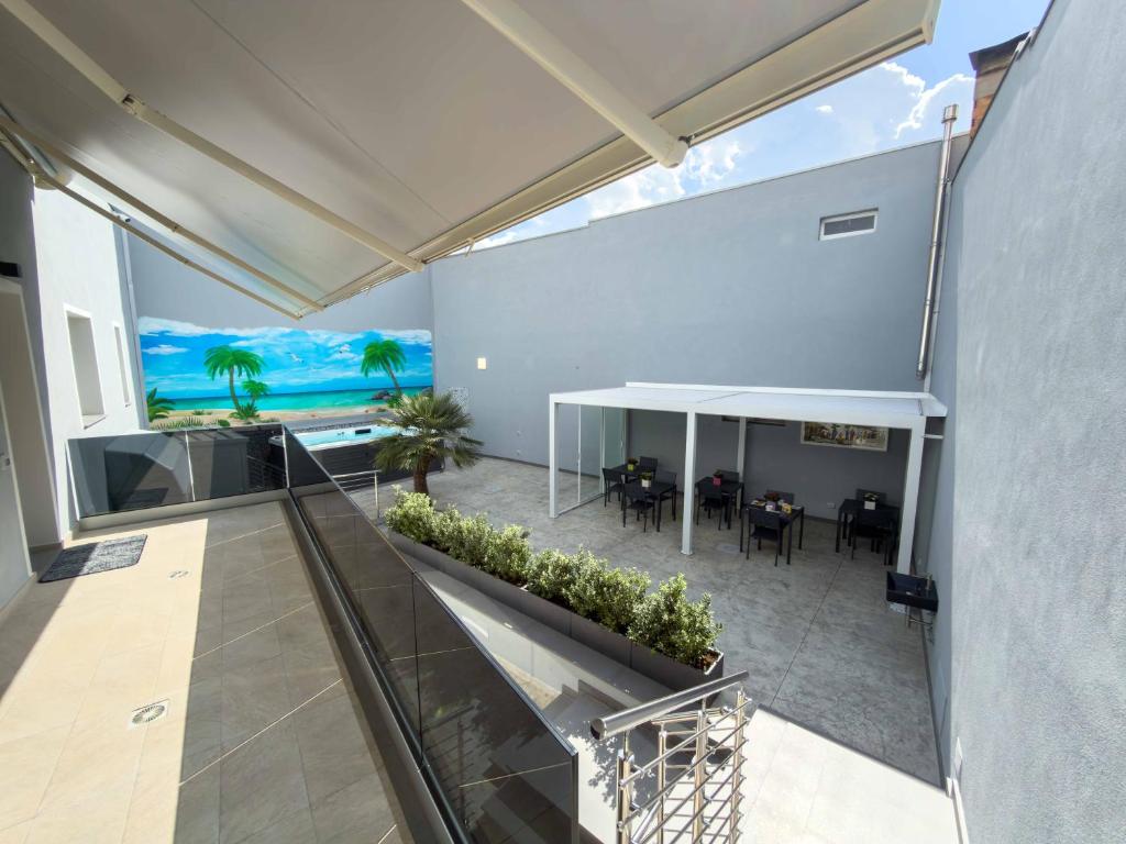 an indoor balcony with a view of a dining room and ocean at Cattleya Rooms in Sestu