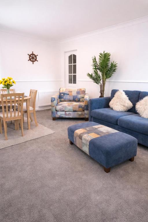 a living room with blue couches and a table at Coquet Nest AMBLE in Amble