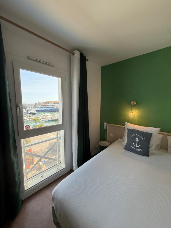 a bedroom with a bed and a large window at Atlantic Hôtel - L'Ile d'Yeu in L'Ile d'Yeu
