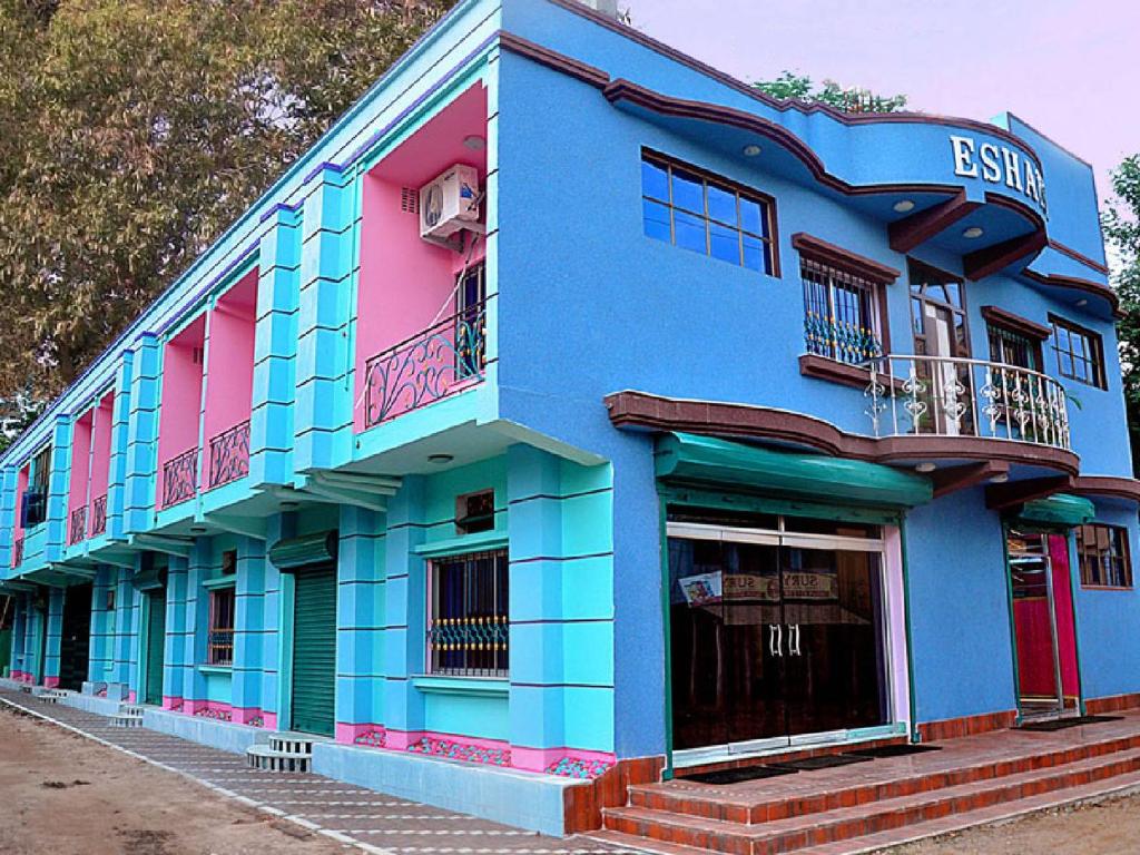 a blue and pink building on the side of a street at Jhargram Eshani Hotels and Guest House in Jhārgrām