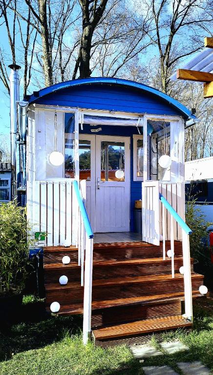 a gazebo with a blue roof and wooden stairs at Cottage-Irina in Brandenburg an der Havel