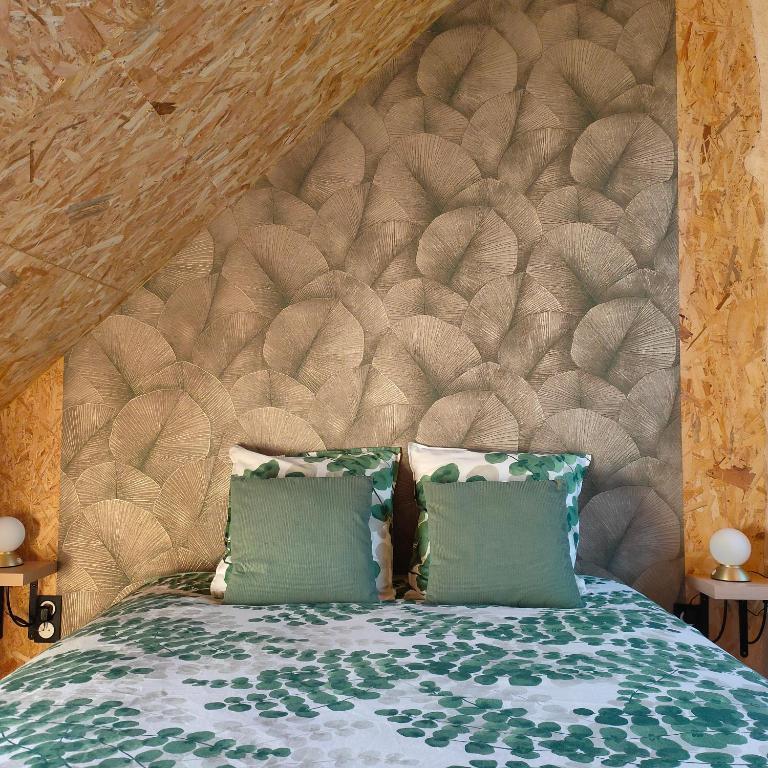 a bed with two pillows and a large headboard at B&B suite de charme in Guipry-Messac