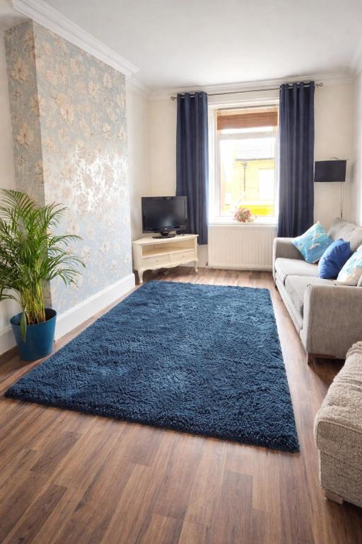 a living room with a couch and a blue rug at Sea Thrift Nook Amble in Amble