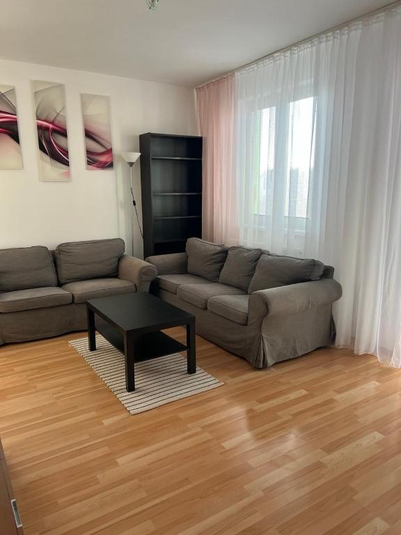 a living room with a couch and a coffee table at Iris Apartment in Dunajská Streda