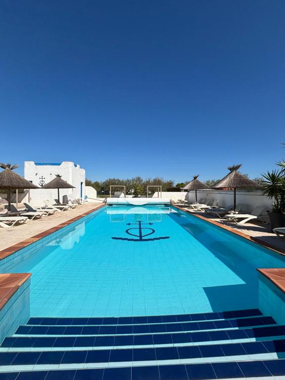 a large swimming pool with blue water at Clamador in Saintes-Maries-de-la-Mer