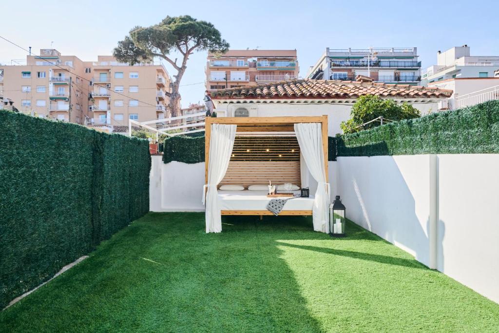 a small balcony with a hammock on a green lawn at CASA CALMA Blanes in Blanes