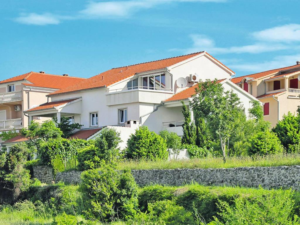 a large white house with a red roof at Apartments Maria Rab in Barbat na Rabu