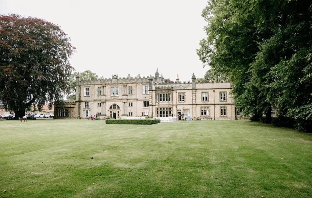 a large house with a large grass field in front at The Old Lodge in Malton