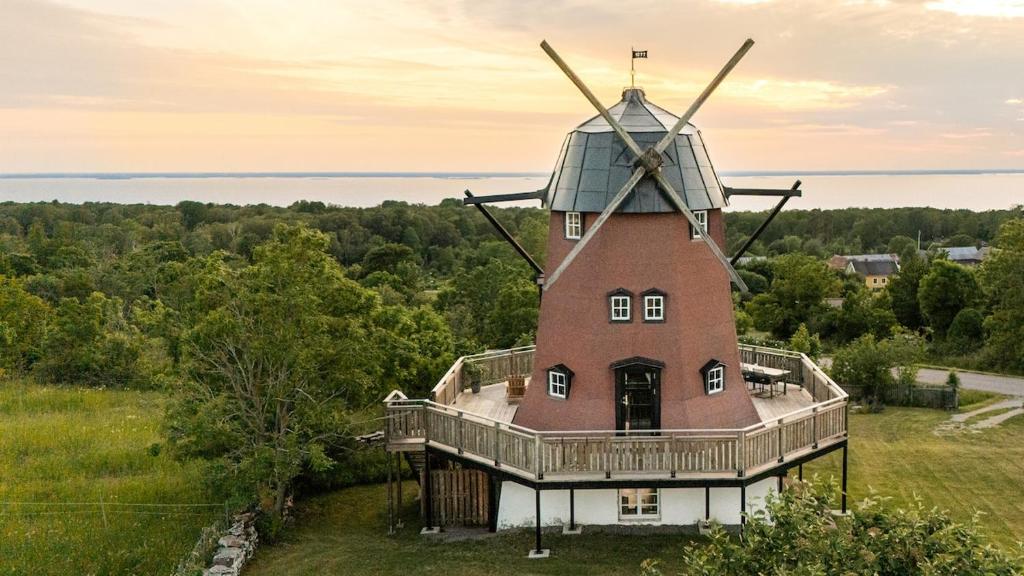 a house with a windmill on top of it at Windmill with the best sunset view in Borgholm