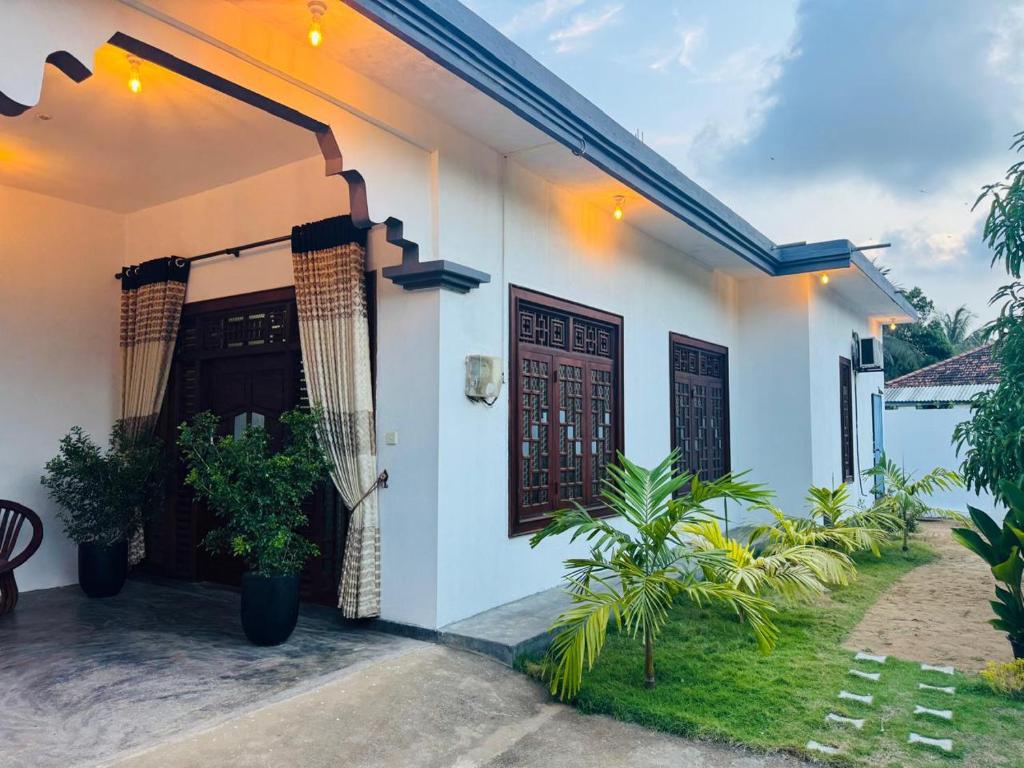 a white house with plants in front of it at Rilu Surf Stay Arugambay in Arugam Bay