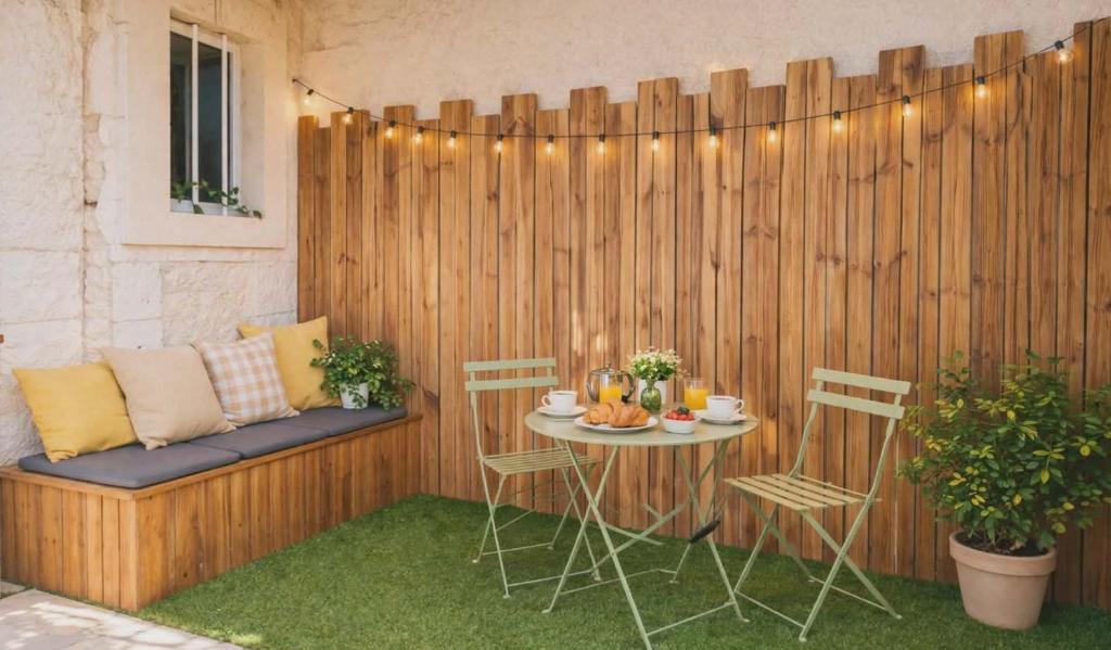 a patio with a table and chairs and a fence at Le Petit Rochalais - Appartement cosy avec terrasse et parking in La Roche-Chalais