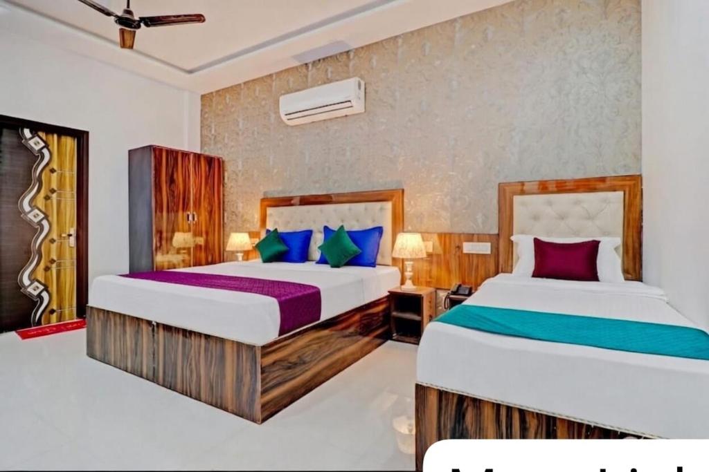 two beds in a hotel room with two beds at The MoonLight Hotel in Zirakpur