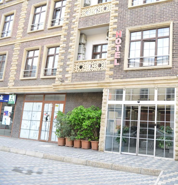 a brick building with plants in front of it at Jupiter -ZamZam-Madinah Halal Hotels Group in Baku