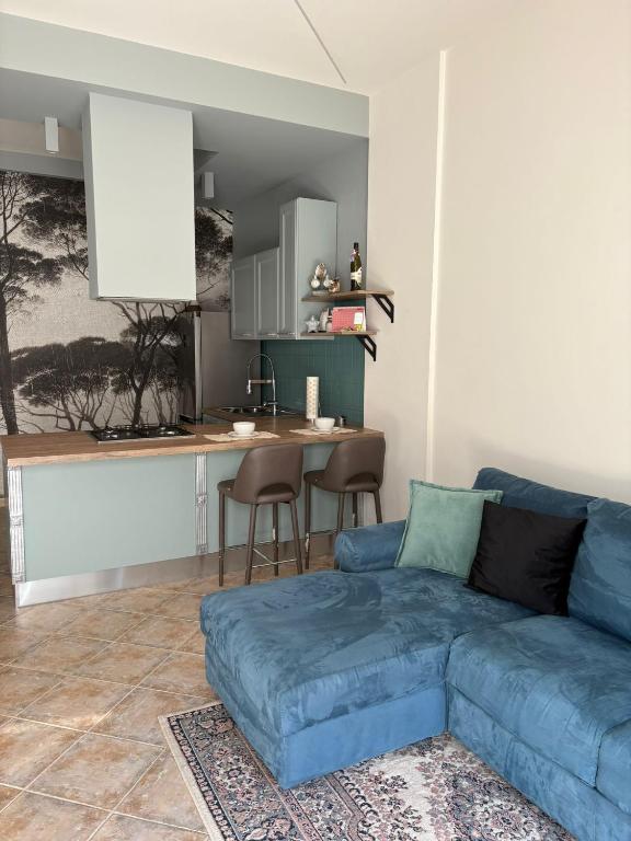 a living room with a blue couch and a kitchen at Appartamento Accogliente tra Borghi e Natura in Castelluccio dei Sauri