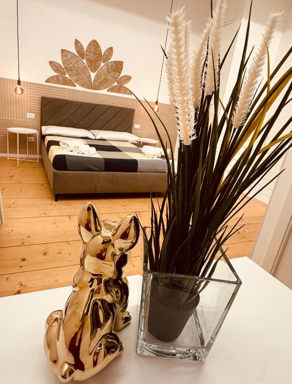 a vase sitting on a table next to a bedroom at Eureka Apartment in Noto