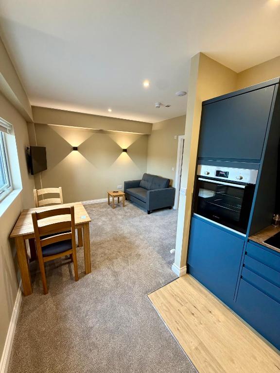 a living room with a large flat screen tv and a table at Grindal Studio Apartments - Newly Opened Luxury Accommodation in St Bees