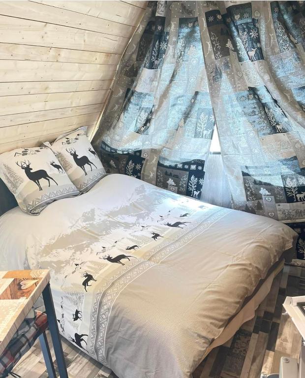 a bed in a room with a window at L écureuil in Granges-Aumontzey