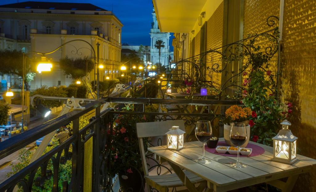 een tafel op een balkon met een glas wijn bij B&B Eco in Pompei