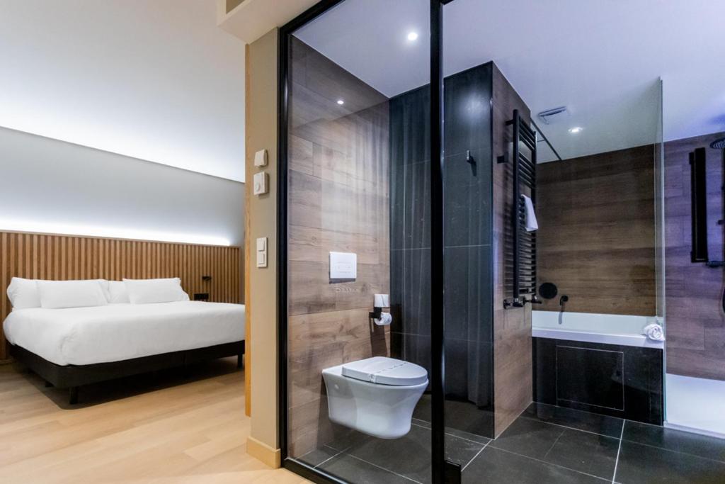 a bathroom with a bed and a toilet and a shower at Hq La Galeria in Burgos