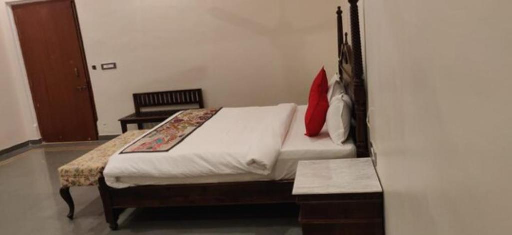 a bedroom with a large bed with a red pillow at Tej Gadh Jambuda in Sālūmbar
