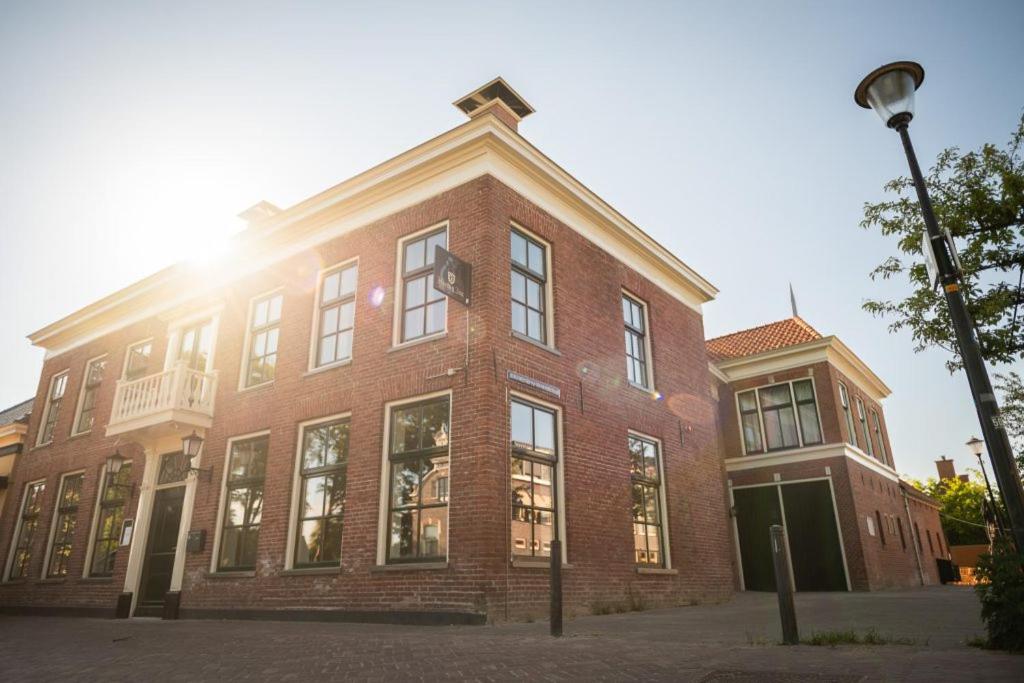 a brick building with the sun shining on it at L'Hopster Dorpsbrouwerij in Loppersum