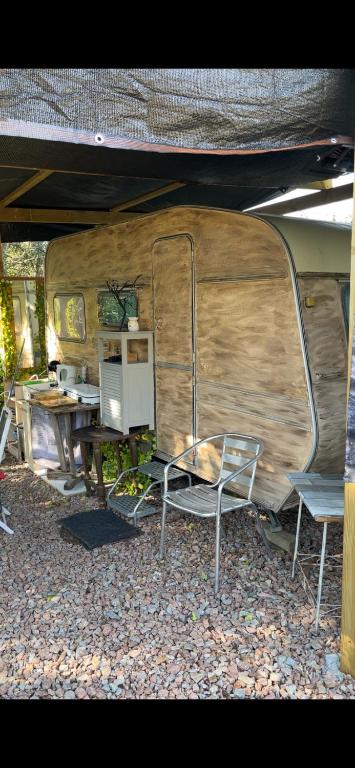 a room with a table and chairs under a tent at Roulotte individuelle dans le maquis Corse in Pianottoli-Caldarello