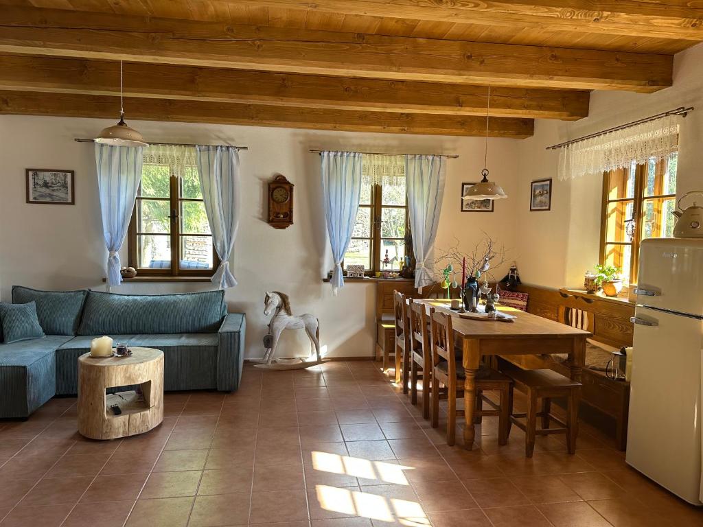 a kitchen and living room with a blue couch and a table at Chalupa Vlachovice in Vlachovice