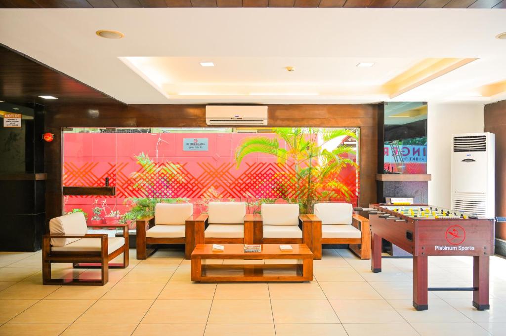 a room with a table and chairs and a board at Ginger Vadodara ,Alkapuri in Vadodara