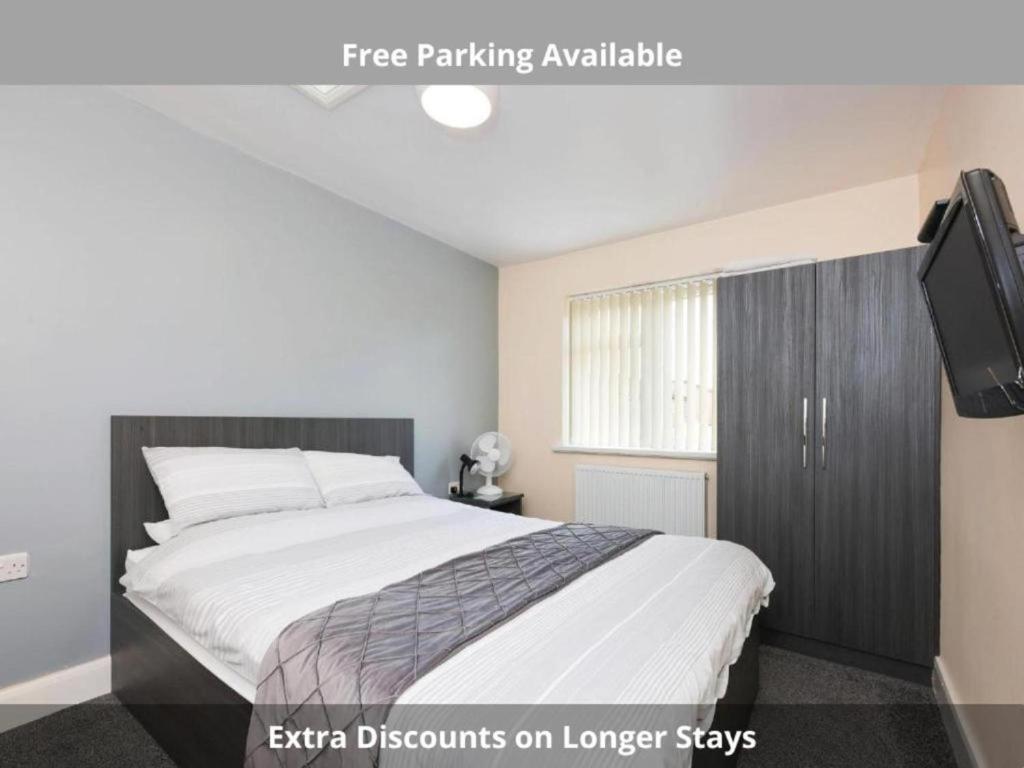a bedroom with a large bed and a tv at OYO Honeycroft Lodge, Uxbridge in Uxbridge
