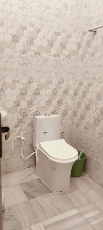 a white bathroom with a toilet and a sink at Nikunj dham in Vrindāvan