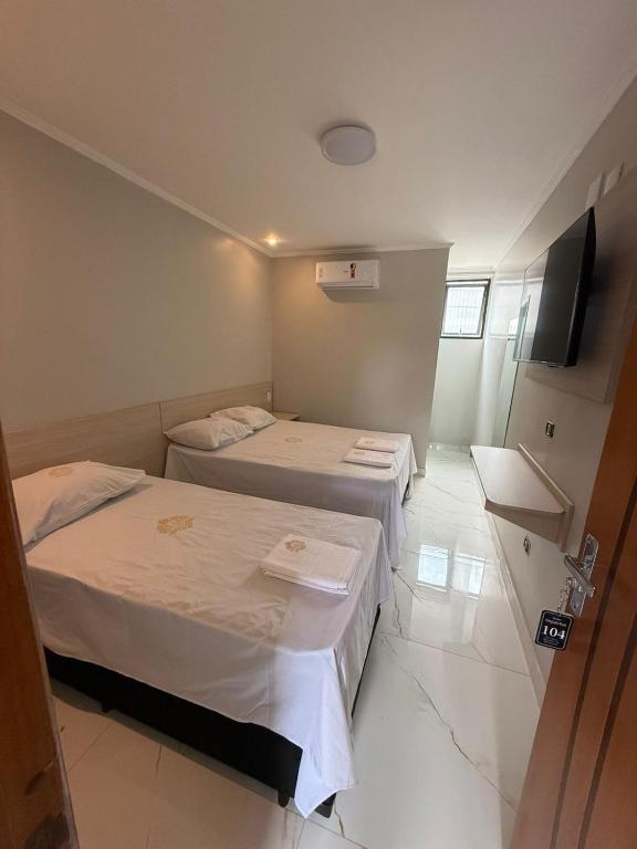 a hotel room with two beds and a television at Hotel Impactus Santo Amaro in São Paulo