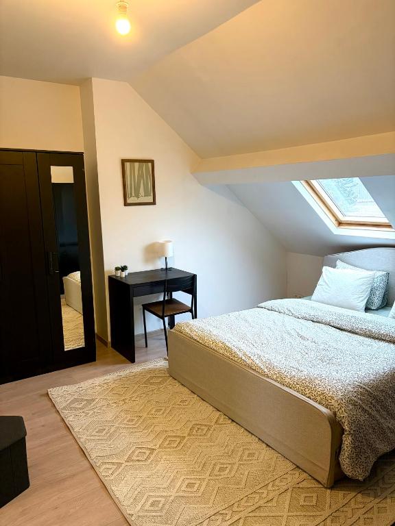 a bedroom with a bed and a desk at Hébergement proche de Atomium Expo Serres Royales in Grimbergen