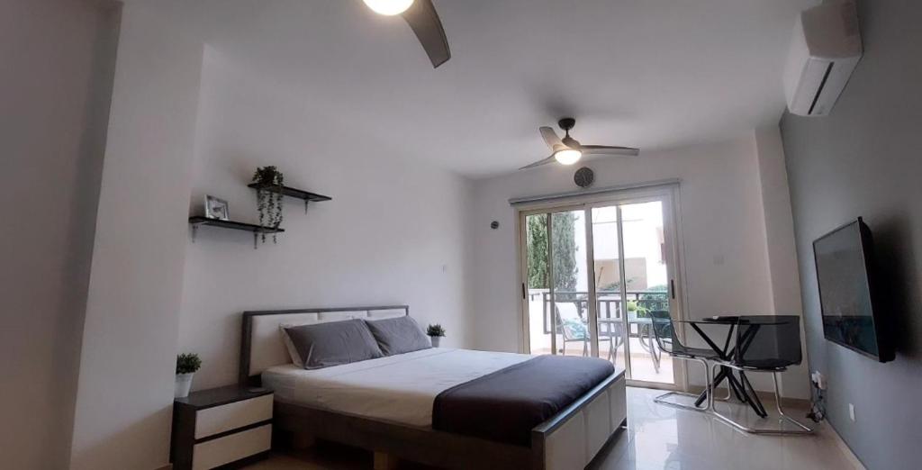 a bedroom with a bed and a tv and a window at Modern Studio apartment Armonia Court in Paralimni