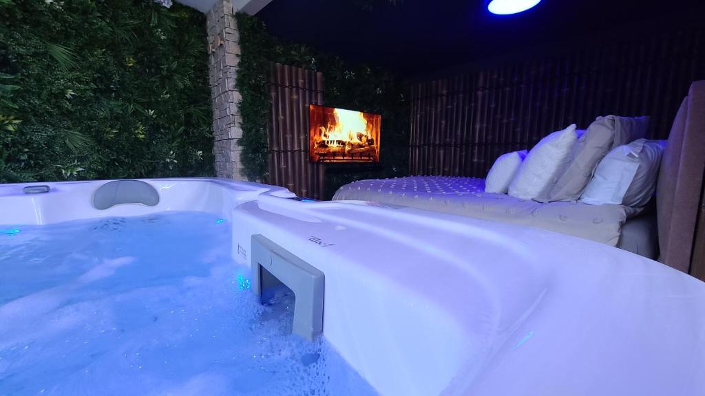 a jacuzzi tub with two beds in a room at Love room le bain in Le Val