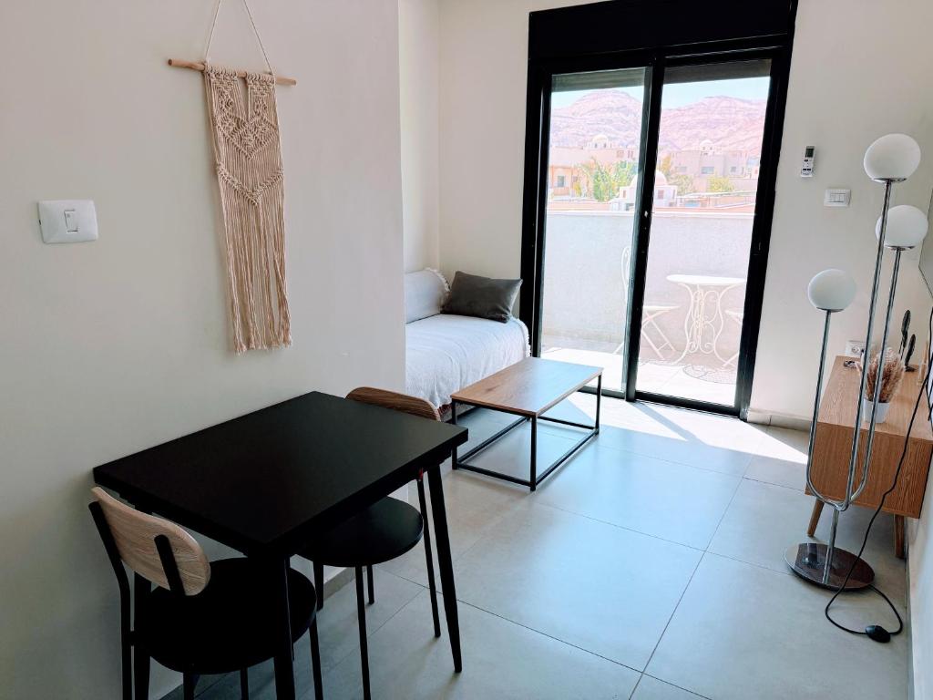 a living room with a black table and a bed at סוויטת ארגמן in Beʼer Ora
