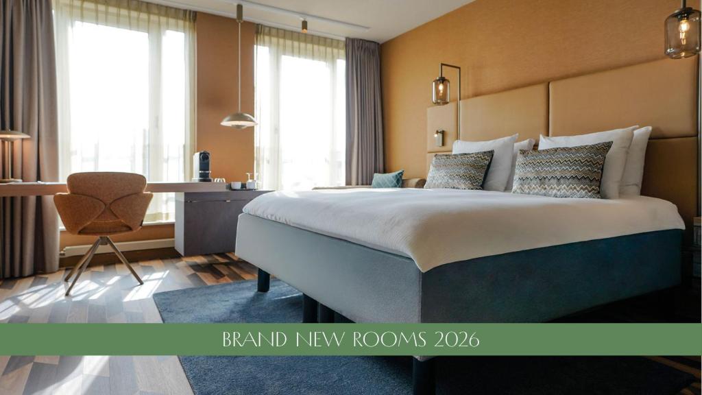 a bedroom with a bed and a desk with a chair at Carlton Oasis Hotel in Spijkenisse