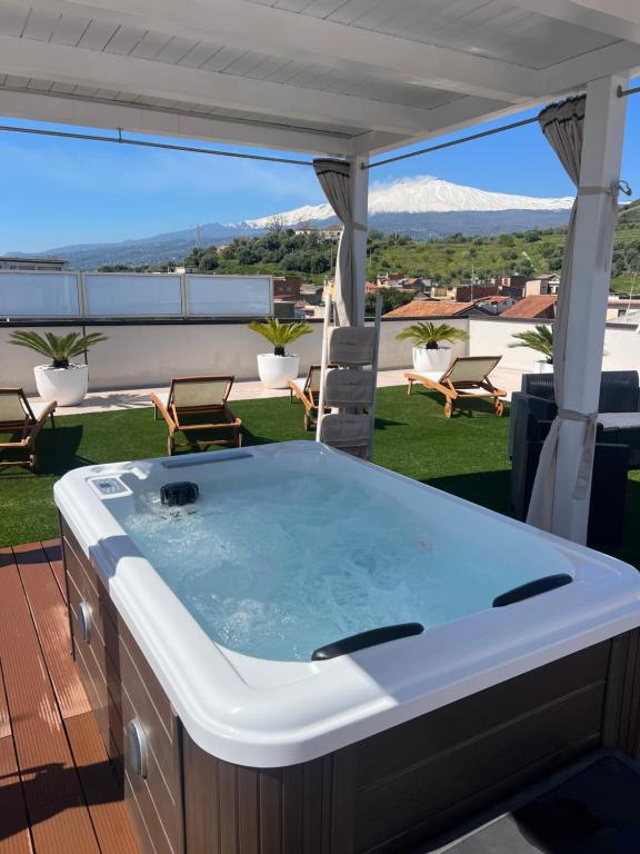 a jacuzzi tub on a balcony with a view at Holiday house ice honey in Calatabiano