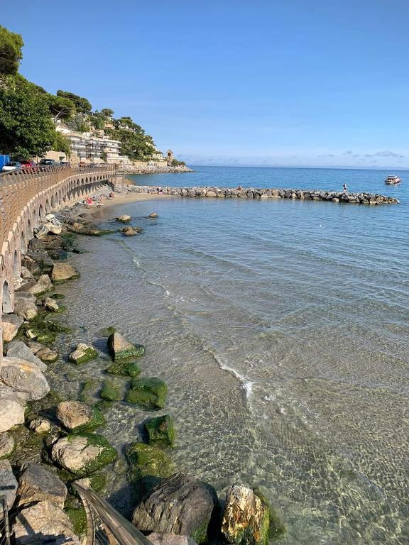 a view of a beach with rocks and the ocean at SunshineSuite in Alassio