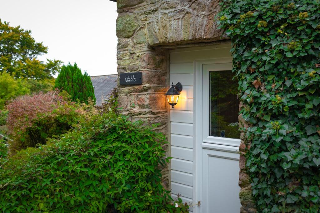 a stone house with a white garage door at Stable Cottage Wheddon Cross in Wheddon Cross