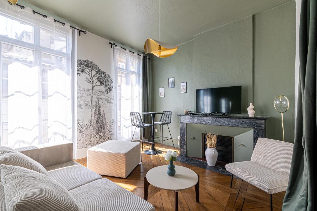 a living room with a couch and a fireplace at EMMA - Centre Historique - Parking privée - CLIM in Auch