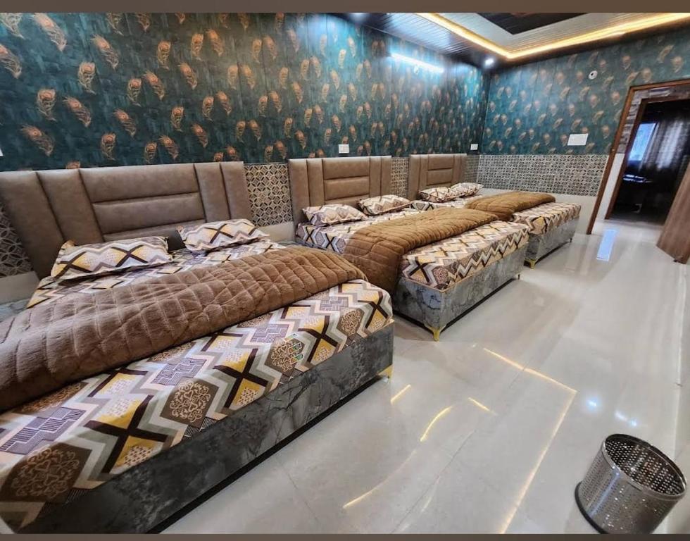 a group of four beds in a room at Hotel Khetan Residency Yamunotri Dham in Kharsālī
