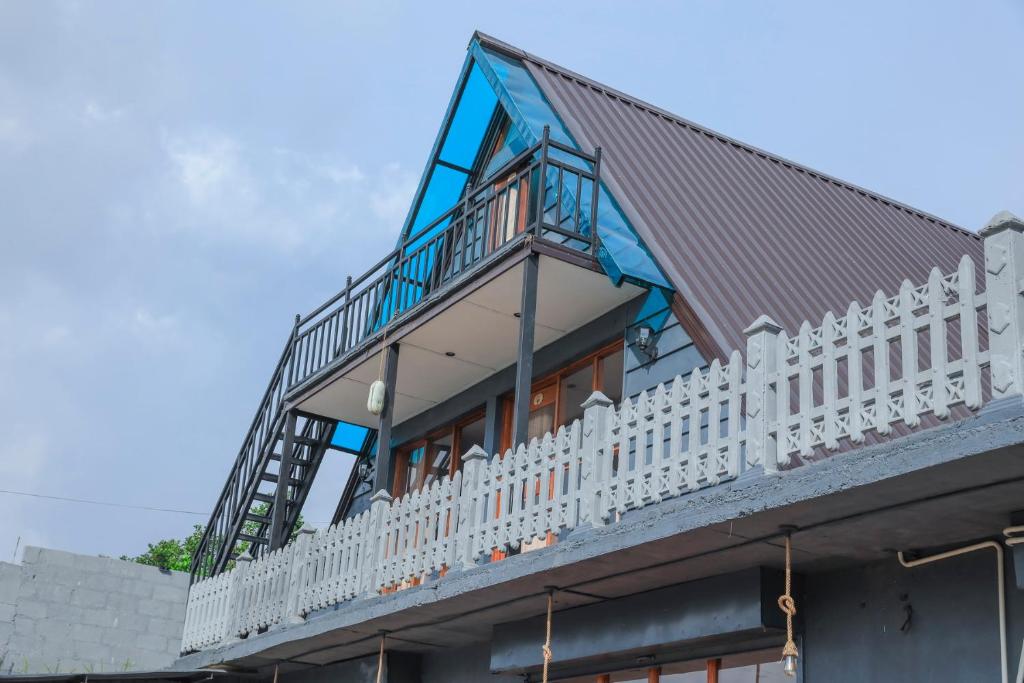 a house with a metal roof and a white fence at Villa Evermist in Nuwara Eliya