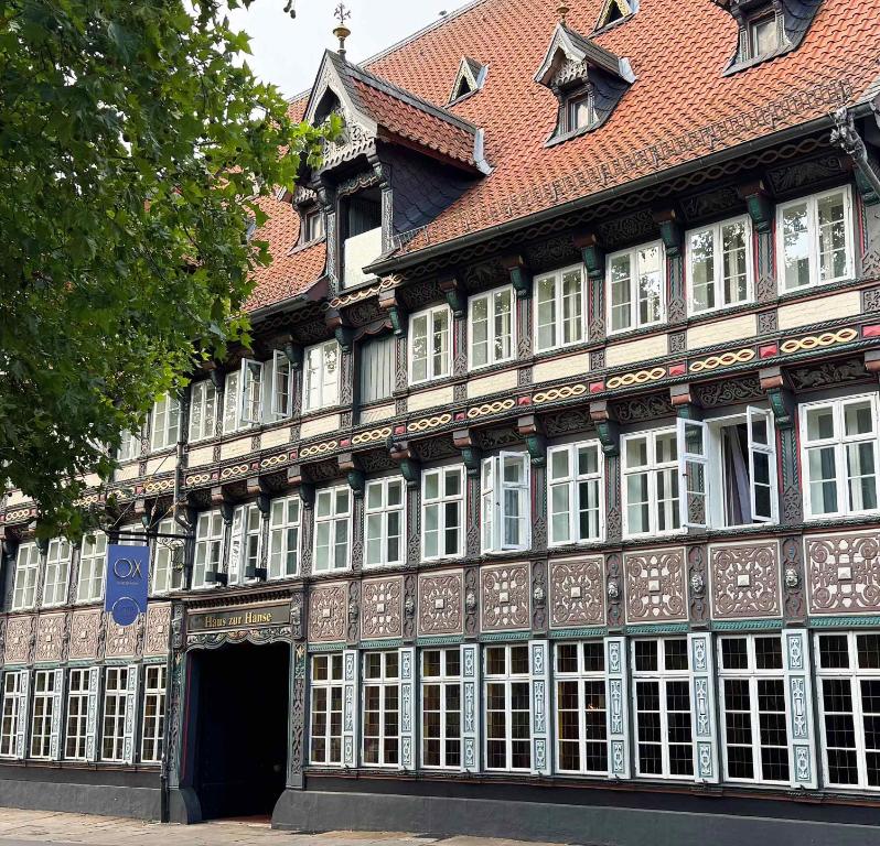 a large building with white windows and a red roof at Hotel im Haus zur Hanse in Braunschweig