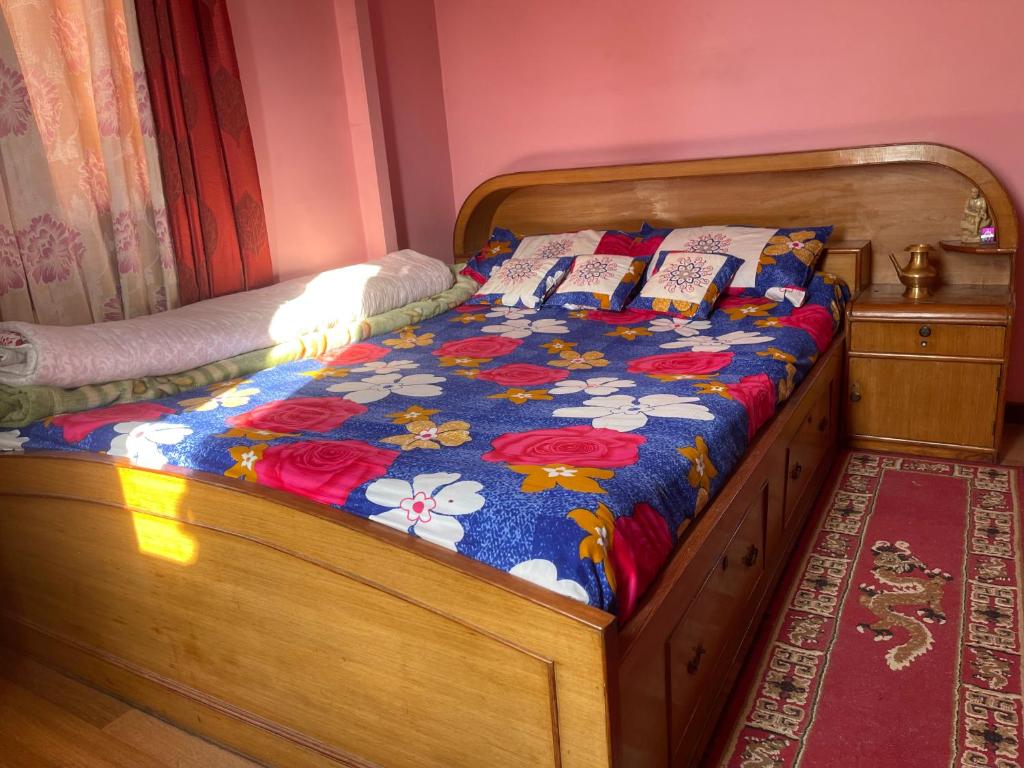 a bed with a wooden frame in a bedroom at Nagdaha homestay in Pātan